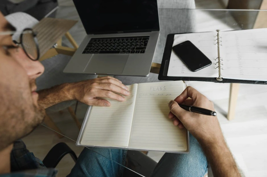 Osoba zapisująca cele rozwojowe w notatniku.